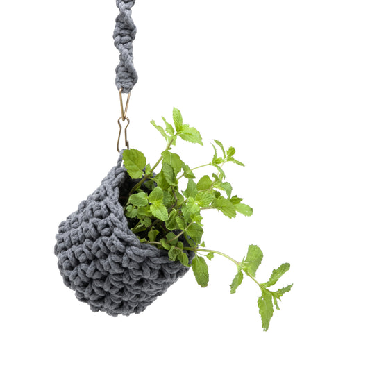 Cachepot Cinza, em crochê artesanal e macramê, com fio 85% algodão e 15% acrílico. Ferragens na cor ouro velho. Dimensões: Altura - 15cm; Diâmetro - 12cm.