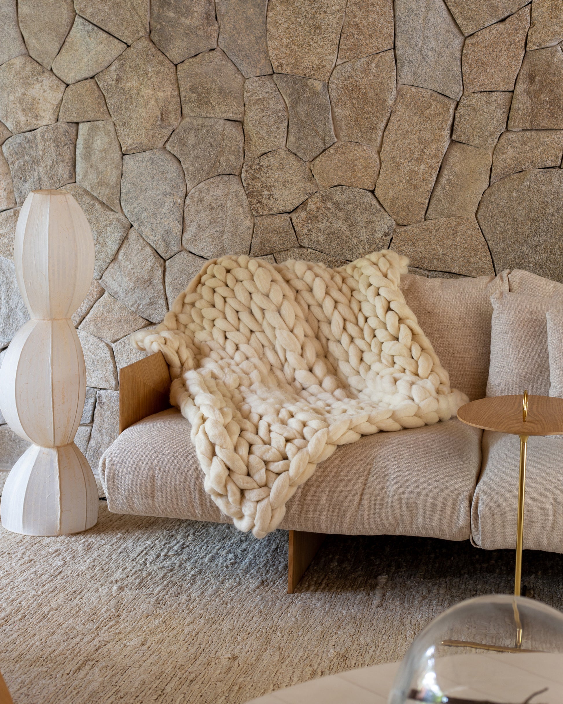 Maxi Manta em tricô artesanal Cru, feita com lã Corriedale 100% natural, sem tingimento. Cinto de couro Marrom, com fivela de metal.