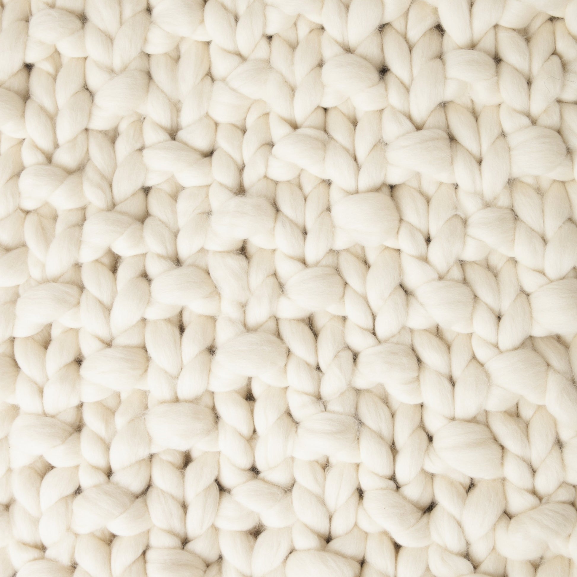 Maxi Manta em tricô artesanal Cru, feita com lã Corriedale 100% natural, sem tingimento. Cinto de couro Preto, com fivela de metal.