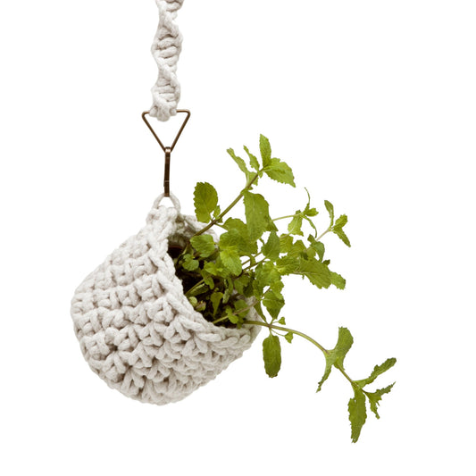 Cachepot Cru, em crochê artesanal e macramê, com fio 100% algodão. Ferragens na cor ouro velho. Dimensões: Altura - 15cm; Diâmetro - 12cm. 